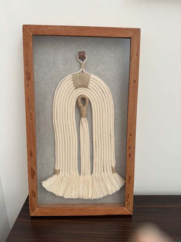 Quadro com macramê creme em forma de arco em moldura de madeira